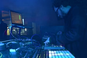 A producer performing live using a mixture of controllers and instruments