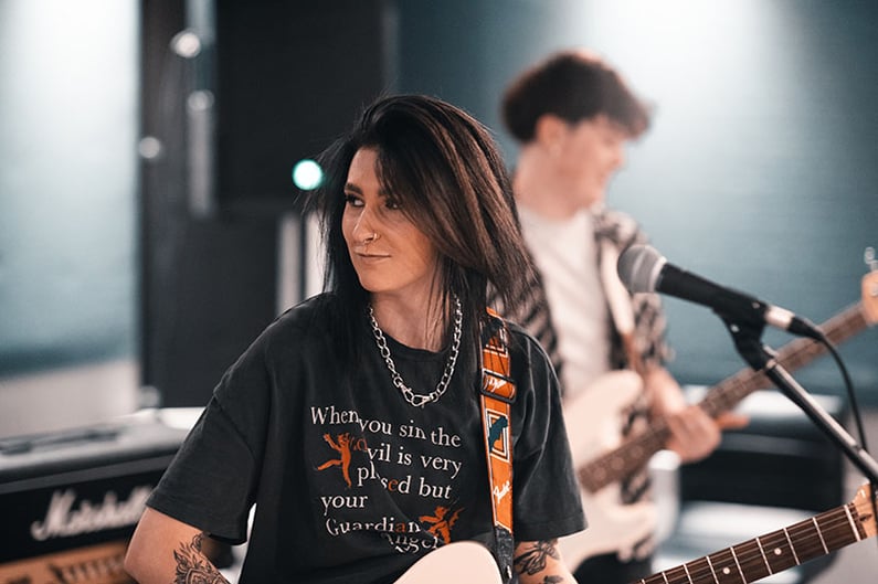 A female guitarist in a live room