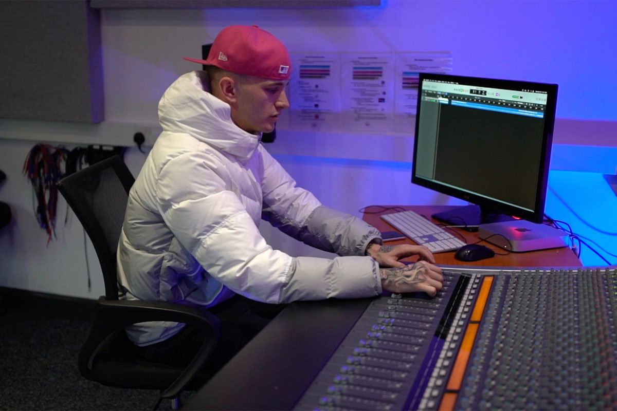 A student making music using the SSL console at dBs Plymouth