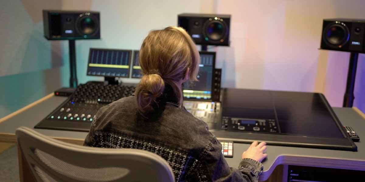 A student mixing in the Dolby Atmos suite