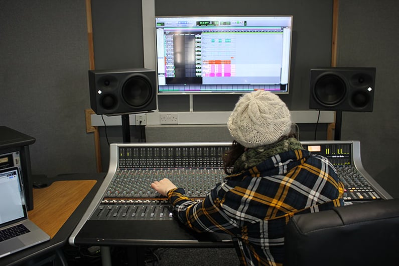 A student producing on the SSL AWS924 desk at dBs Plymouth