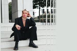 A landscape photo of EMMY sat on a staircase outside a building