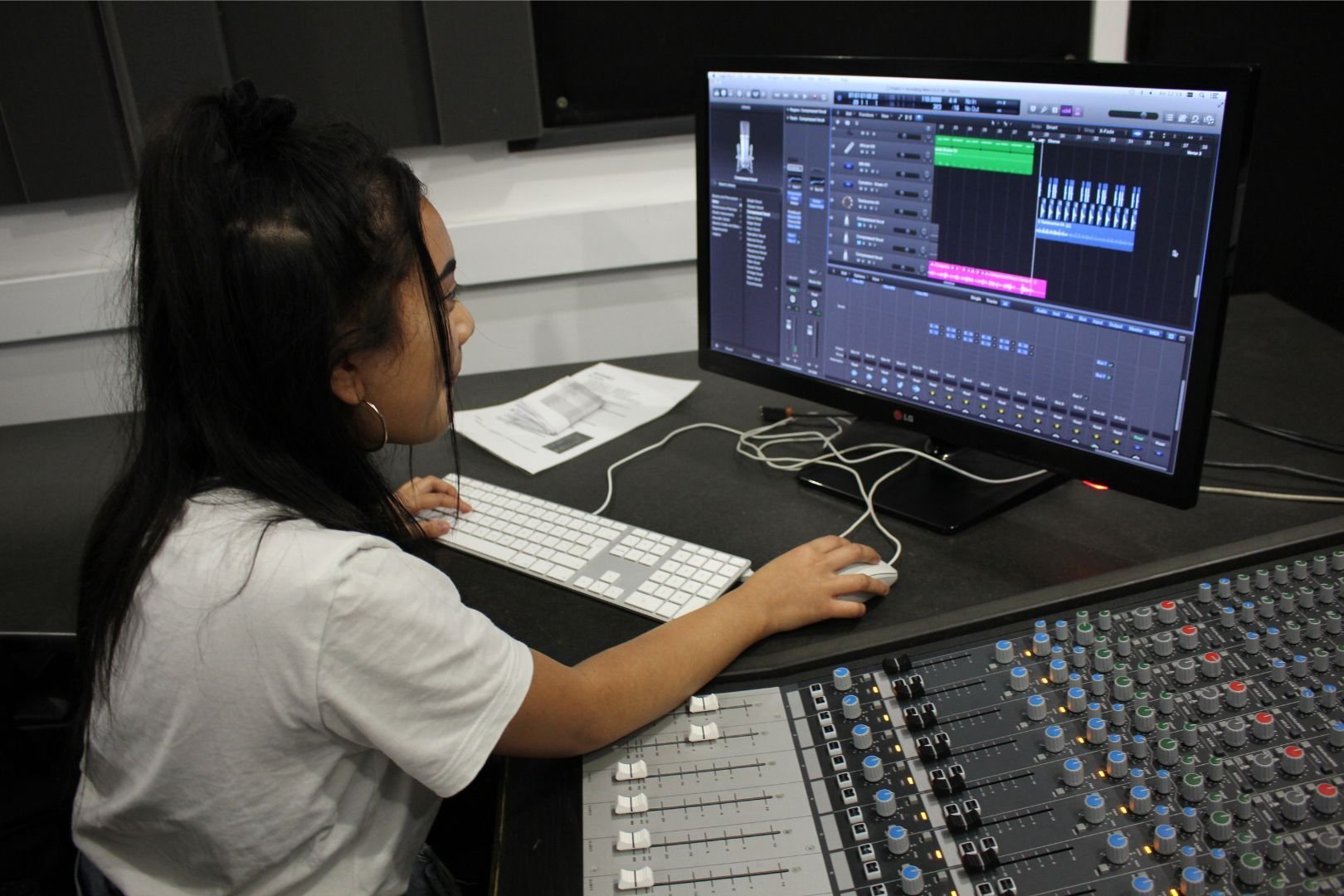 Female dBs student working on mixing console