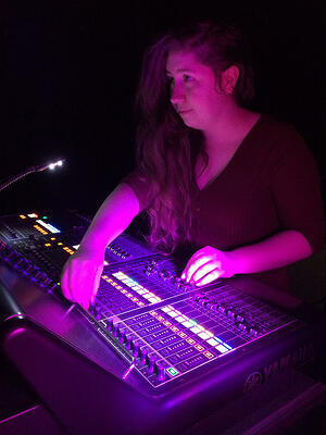 Hazel using a mixing console while working front of house