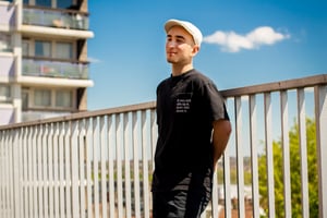 A portrait picture of Juan Sevilla-Campoamor with a tower block of flats in the background