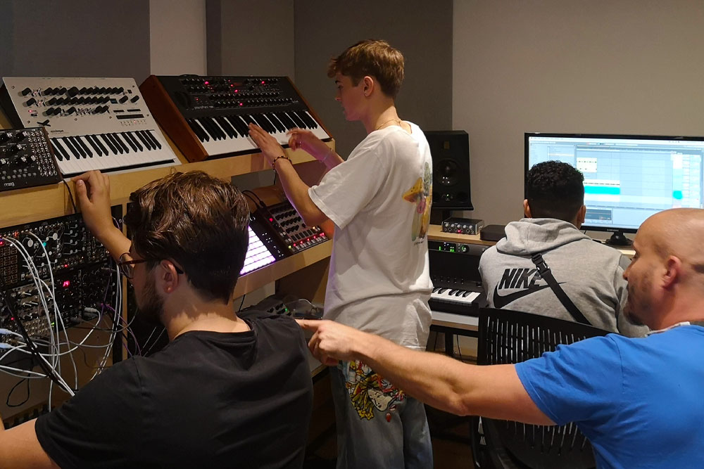 Liam OMullane and a group of students in the production suite