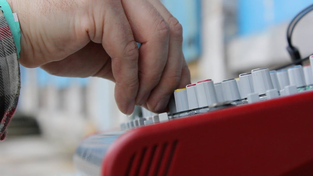 Live sound engineer operating a mixing desk