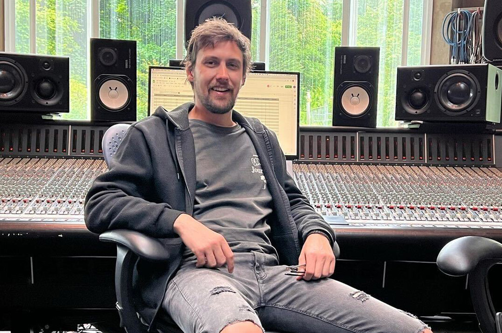 Lucas Banks sat in front of the mixing console at Real World Studios