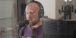 Seamus Maguire recording vocals in a recording booth