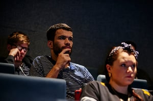A group of attentive students in a lecture theatre